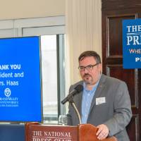 speaker at podium with slide show